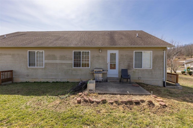 rear view of house featuring roof with shingles, a yard, and a patio