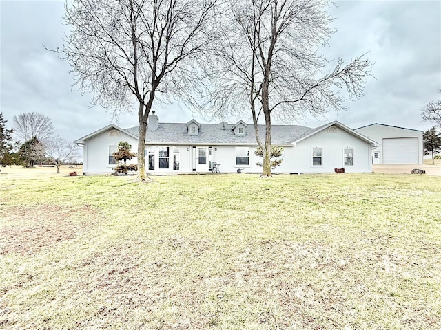 rear view of house with a garage and a lawn