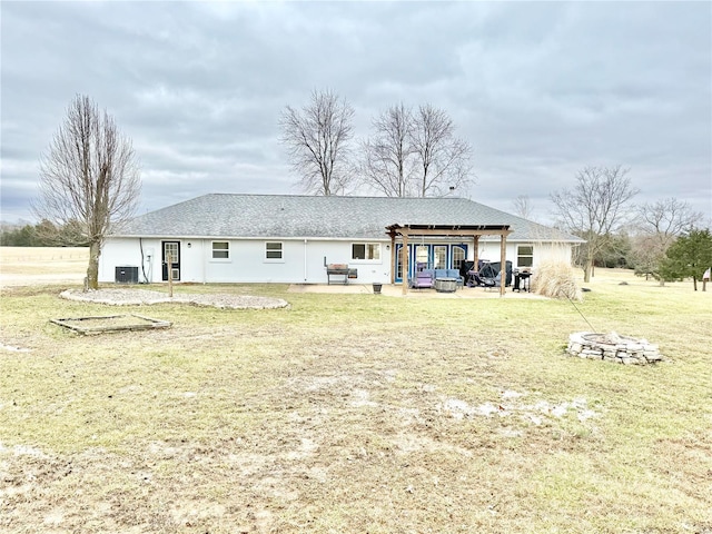 rear view of property with central AC, a patio, a fire pit, and a lawn