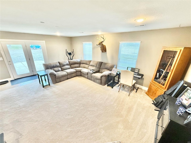 living area with baseboards, visible vents, and carpet flooring