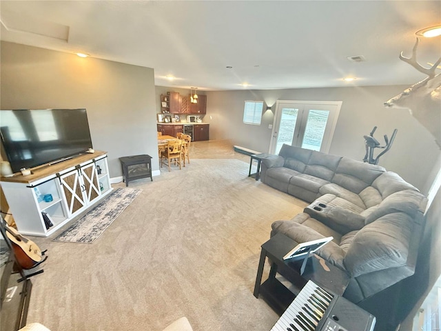 living room featuring carpet, visible vents, and baseboards