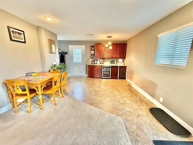 interior space featuring pendant lighting, light countertops, wine cooler, and baseboards