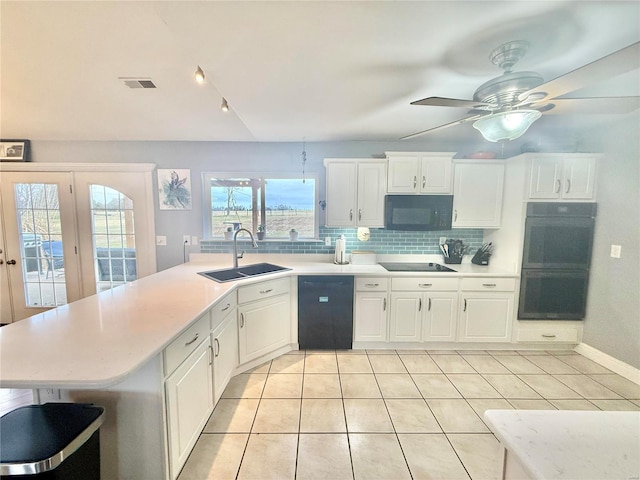 kitchen with a sink, visible vents, light countertops, black appliances, and tasteful backsplash