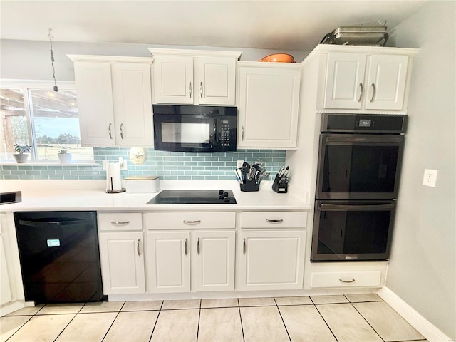 kitchen featuring black appliances, backsplash, light countertops, and white cabinets