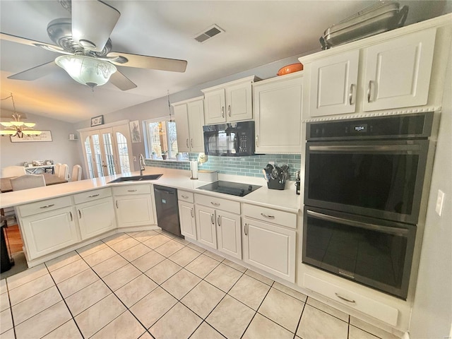 kitchen featuring visible vents, a peninsula, a sink, black appliances, and backsplash