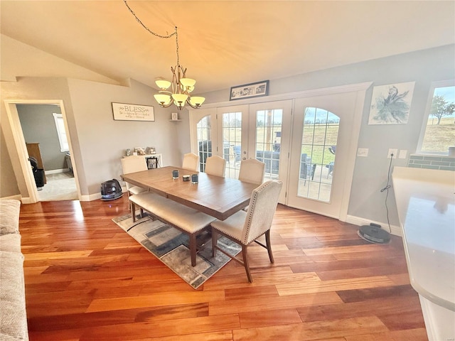 dining room with lofted ceiling, plenty of natural light, and light wood-style flooring