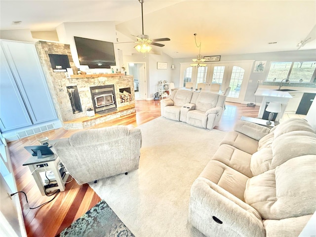 living area featuring light wood-style floors, french doors, visible vents, and vaulted ceiling