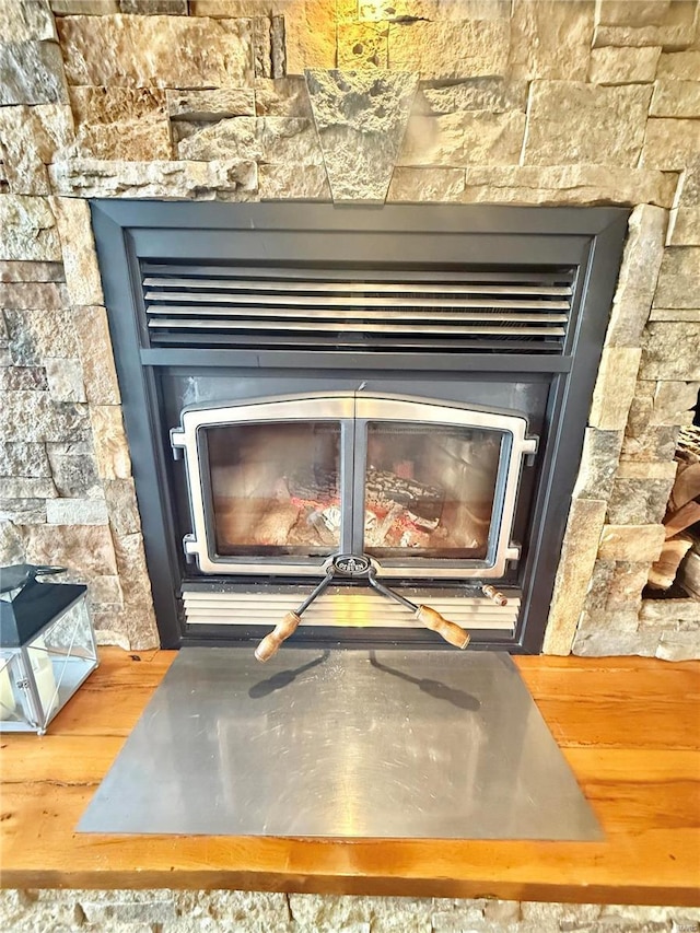 details featuring wood finished floors and a glass covered fireplace