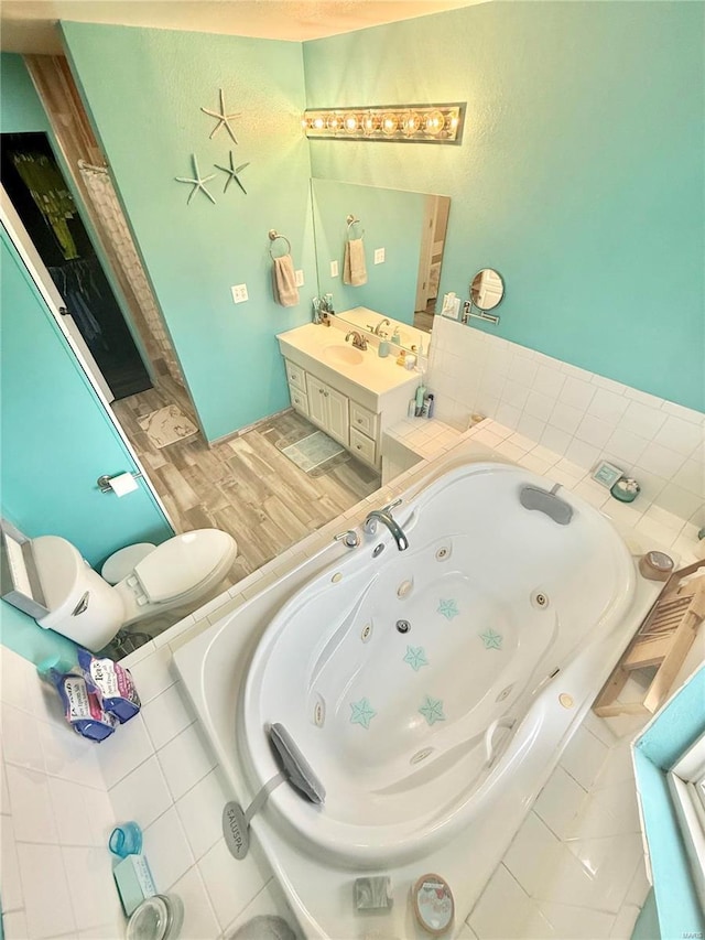 full bath featuring a whirlpool tub and vanity