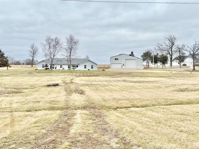 view of yard featuring a garage and an outbuilding