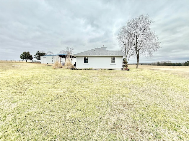 back of property with a chimney and a yard