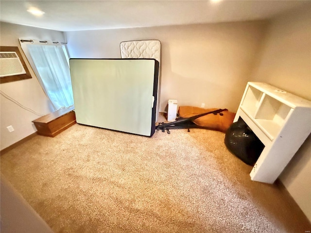 unfurnished bedroom featuring baseboards, a wall unit AC, carpet flooring, and refrigerator