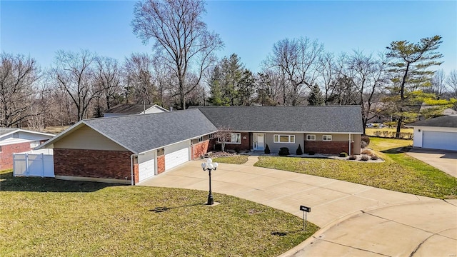 ranch-style home featuring an attached garage, brick siding, fence, driveway, and a front yard