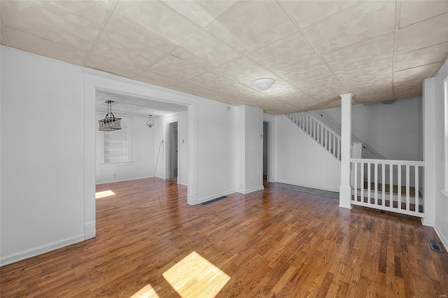 spare room featuring visible vents, stairway, and wood finished floors