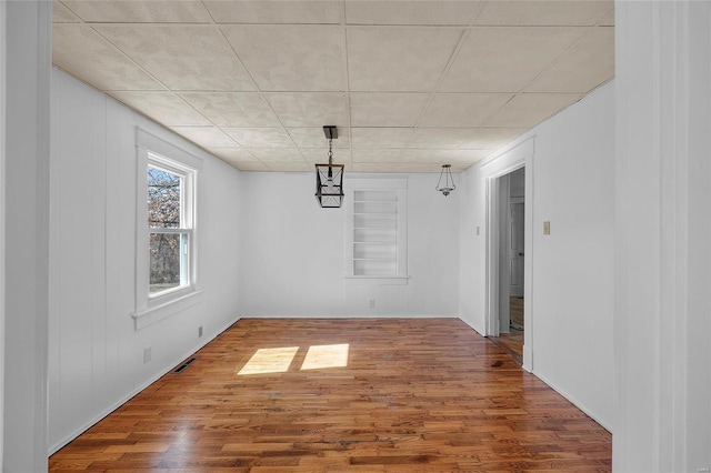 unfurnished dining area featuring visible vents and wood finished floors