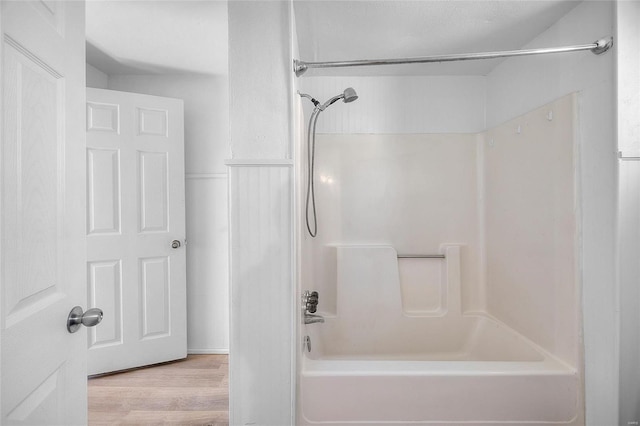 bathroom featuring bathtub / shower combination and wood finished floors