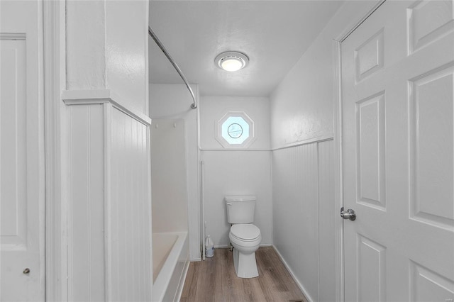 full bathroom featuring a textured ceiling, shower / tub combination, wood finished floors, and toilet