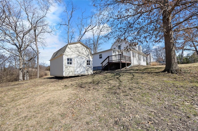 exterior space with a deck, a storage unit, a lawn, and an outdoor structure