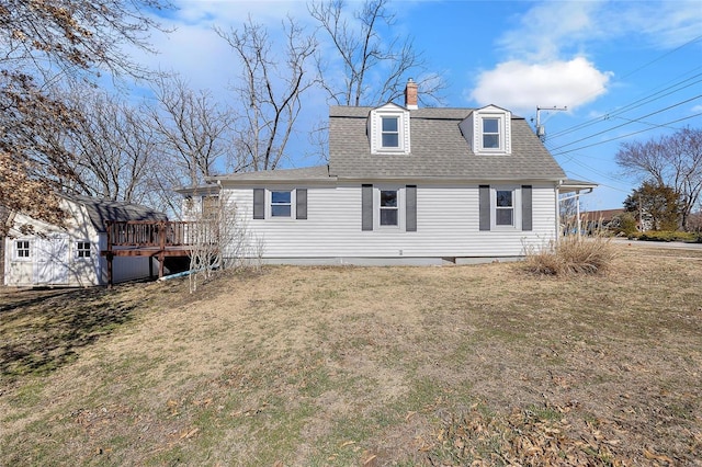 back of house featuring roof with shingles, a lawn, a chimney, and a wooden deck