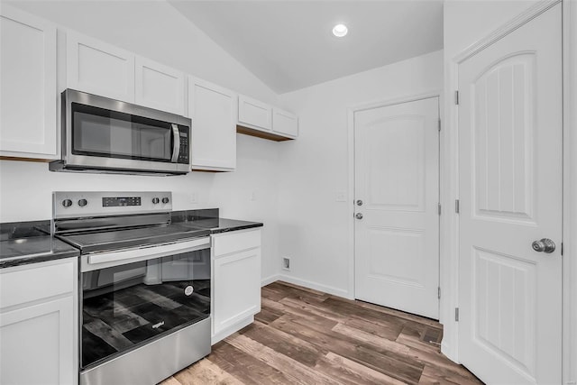 kitchen featuring stainless steel appliances, dark countertops, and white cabinets