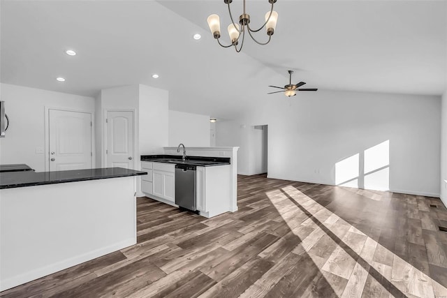 kitchen featuring white cabinets, dishwasher, dark countertops, lofted ceiling, and dark wood-type flooring