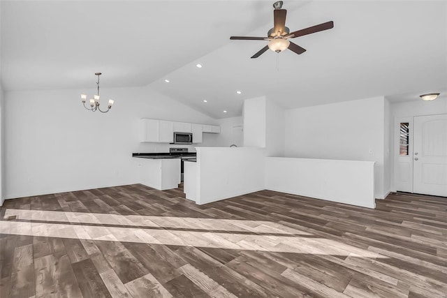 interior space with dark wood-style flooring, white cabinetry, vaulted ceiling, stainless steel microwave, and dark countertops