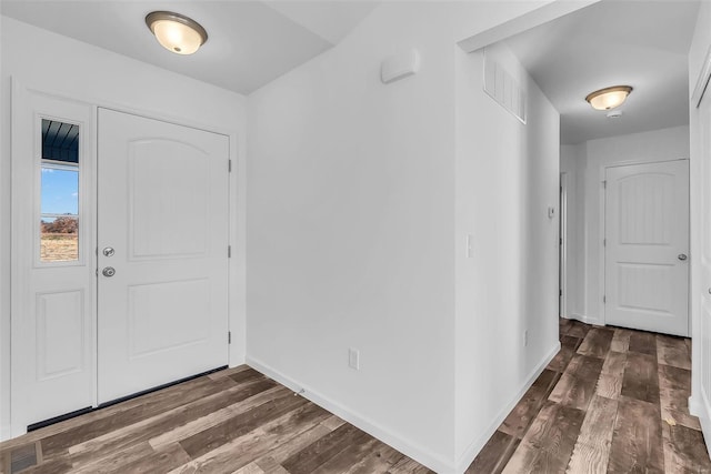 entrance foyer featuring baseboards, visible vents, and dark wood-type flooring