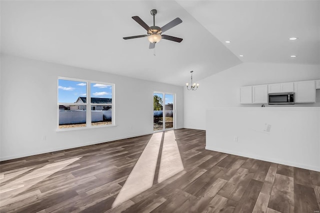 unfurnished living room with dark wood-type flooring, lofted ceiling, recessed lighting, and ceiling fan with notable chandelier