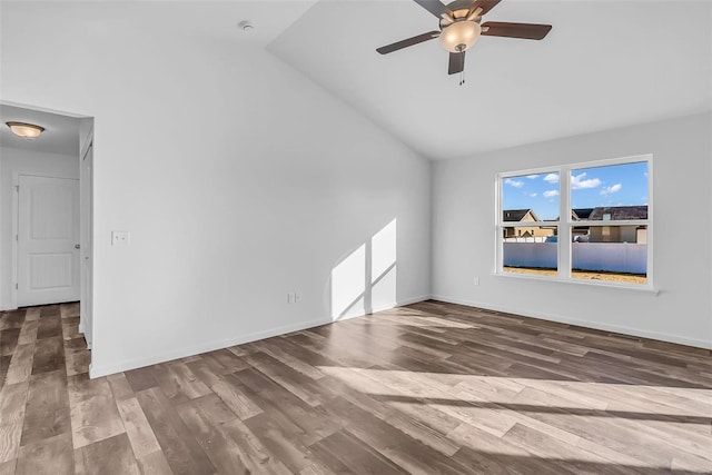 unfurnished room featuring lofted ceiling, wood finished floors, a ceiling fan, and baseboards