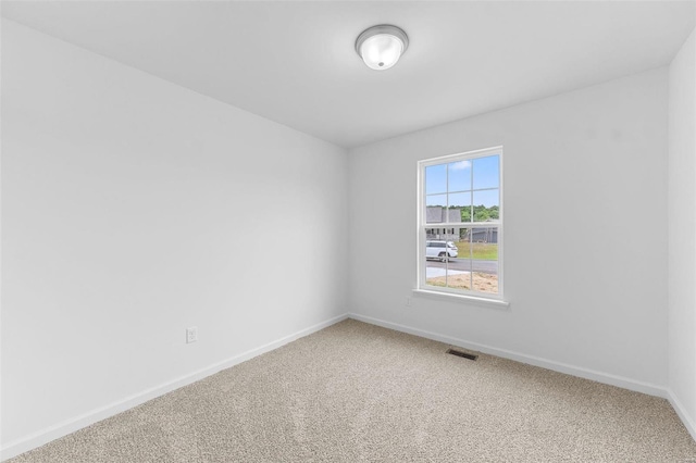 carpeted spare room with visible vents and baseboards