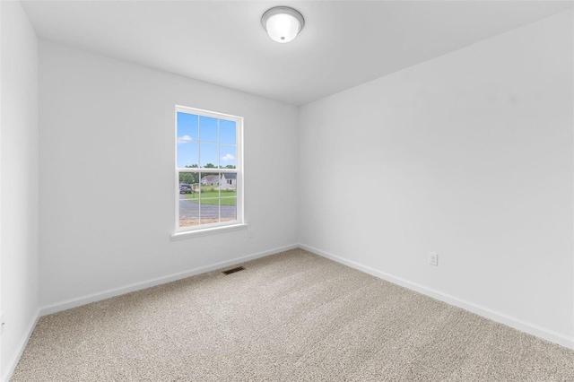 unfurnished room featuring carpet floors, baseboards, and visible vents