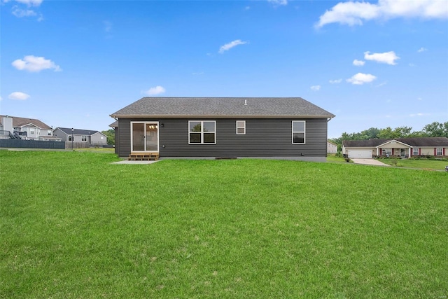 back of property with entry steps and a lawn