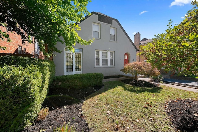 back of house featuring a yard and stucco siding