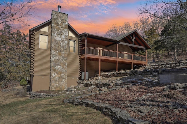 exterior space with log exterior, a lawn, and a chimney