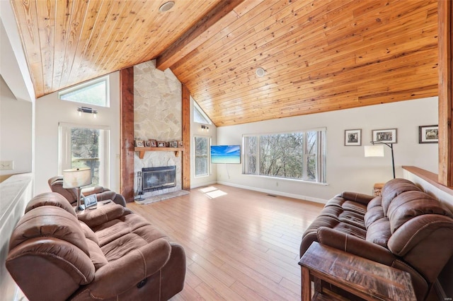 living area featuring baseboards, wood ceiling, hardwood / wood-style floors, a stone fireplace, and high vaulted ceiling