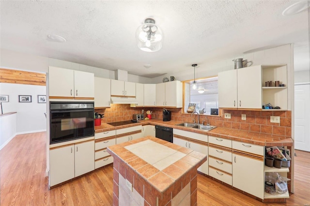 kitchen with light wood-type flooring, black appliances, open shelves, a sink, and under cabinet range hood