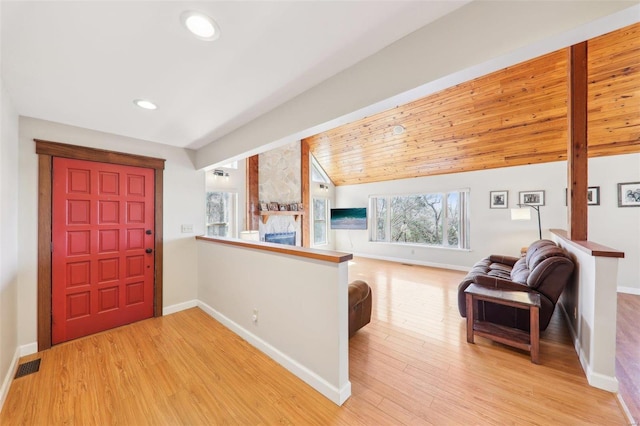 entrance foyer featuring visible vents, wood finished floors, a large fireplace, baseboards, and vaulted ceiling