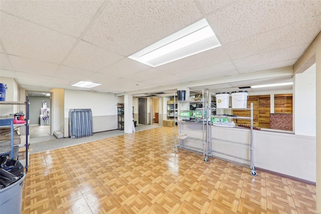 interior space featuring a paneled ceiling and baseboards