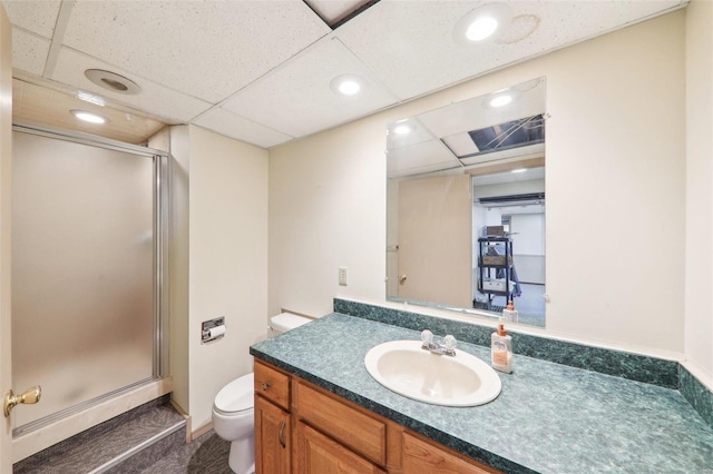 bathroom with vanity, recessed lighting, a stall shower, a drop ceiling, and toilet