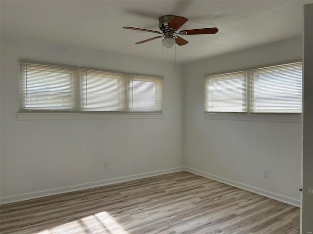 unfurnished room with wood finished floors, a ceiling fan, and baseboards