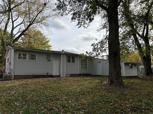 rear view of house featuring a yard