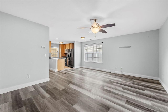 unfurnished living room featuring recessed lighting, baseboards, light wood-style flooring, and a ceiling fan