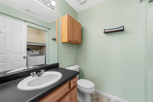 bathroom with vanity, baseboards, visible vents, washer / clothes dryer, and toilet