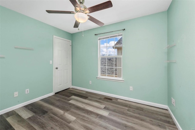 spare room with ceiling fan, baseboards, and wood finished floors