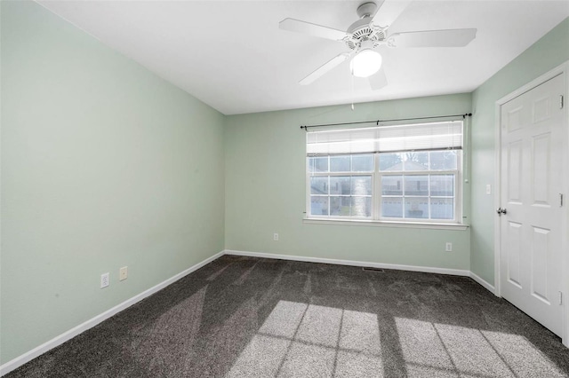 carpeted empty room featuring baseboards and ceiling fan