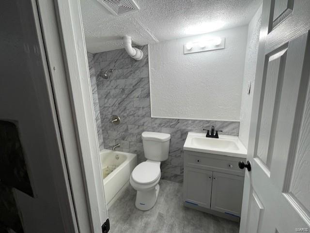 bathroom with visible vents, a textured wall, toilet, a textured ceiling, and vanity