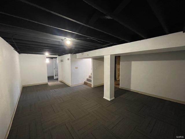 finished below grade area featuring baseboards and stairs