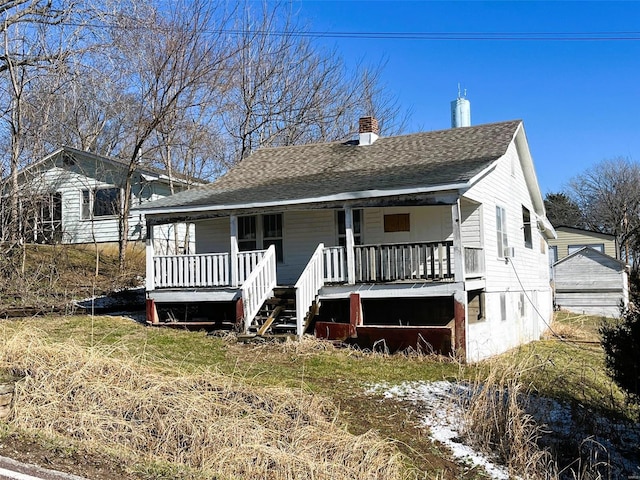 view of front of home with covered porch, a shingled roof, and a chimney