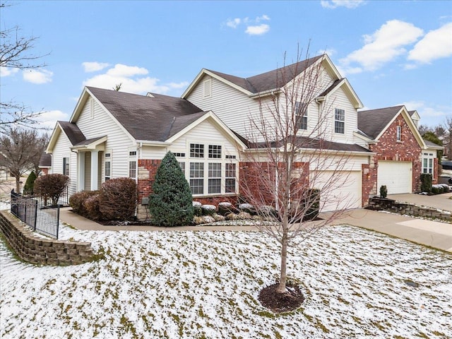 traditional home with a garage, brick siding, and driveway