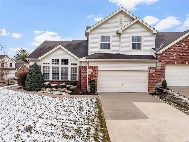 traditional-style house with a garage, driveway, and brick siding